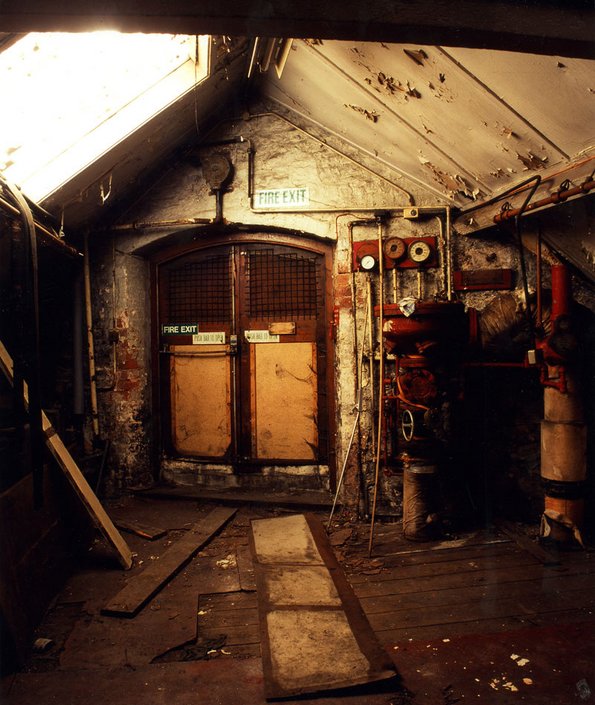 Dimly lit dilapidated interior with machinery